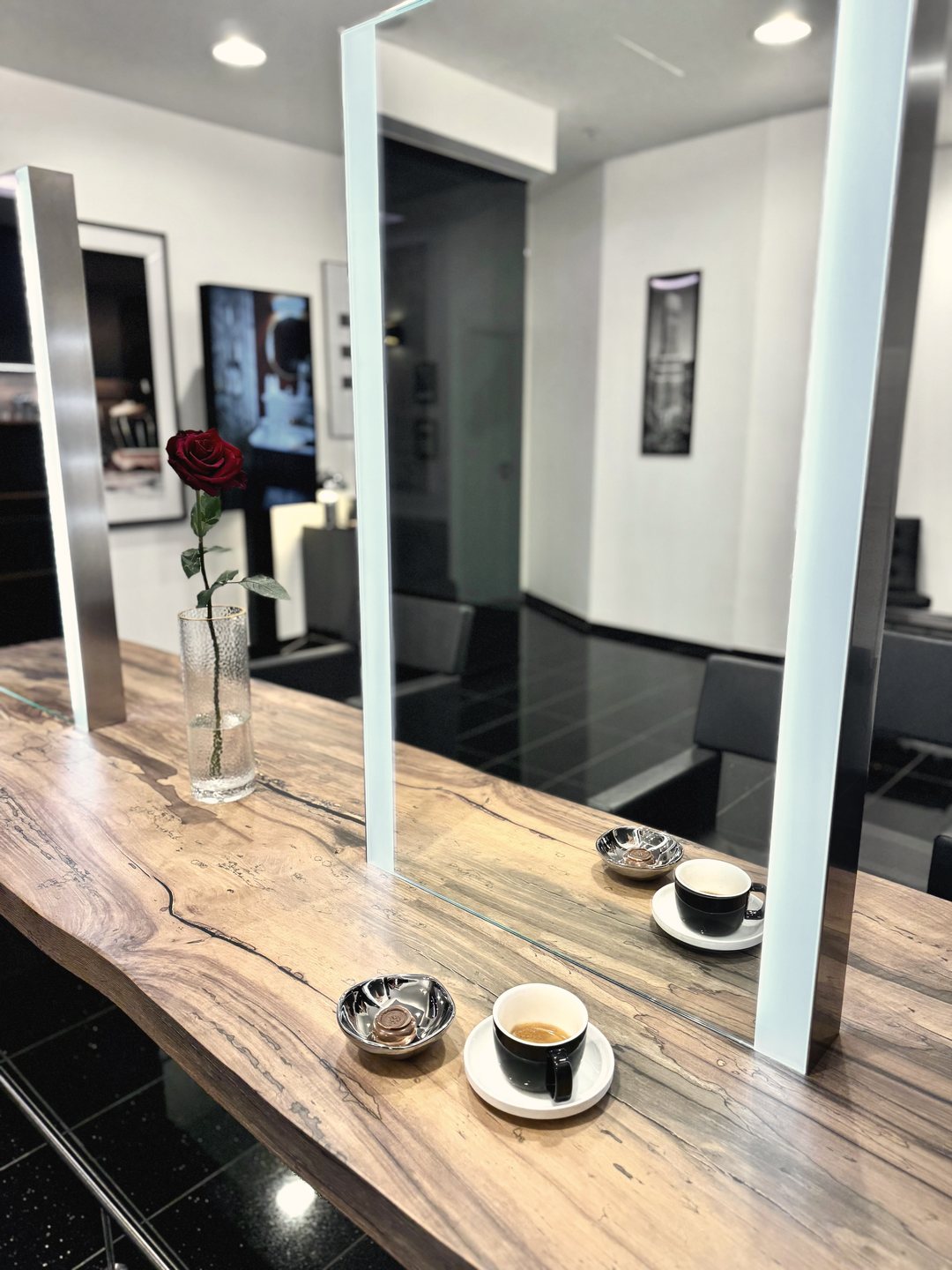Espresso und rote Rose auf dem Holztisch am Spiegelplatz